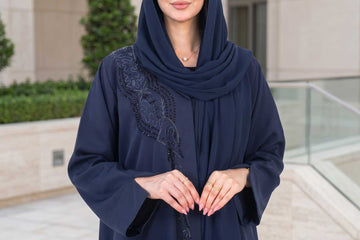 Woman in Navy Sash Abaya with tailored lapel and cascading beaded detail illustrating structured abaya design in Dubai - Layaal