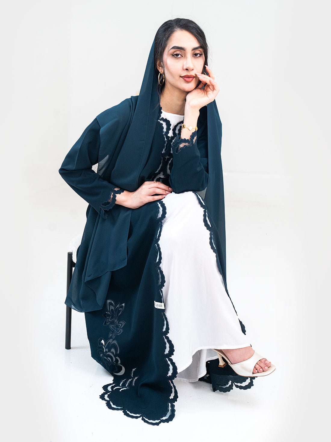 Tidal Luxe Abaya in teal styled seated showing scalloped lace hem and matching shayla - Layaal