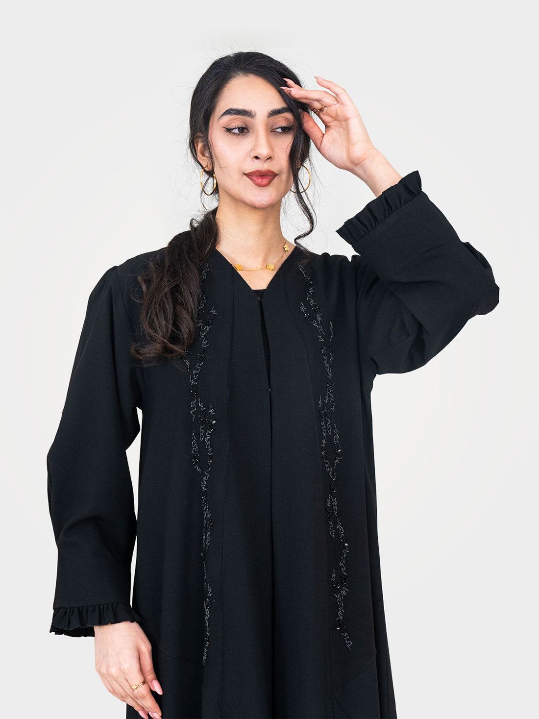 Noir Ruffle Abaya upper body view showing ruffle cuffs and tonal bead sequin embellishment on black twill crepe UAE